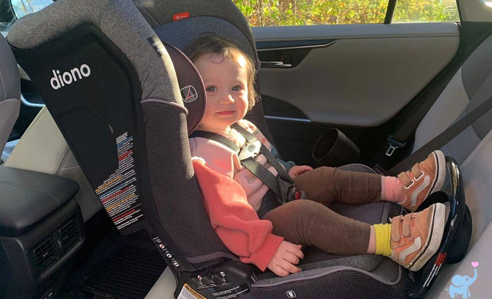 a young child smiling while sitting in the diono 3qx car seat