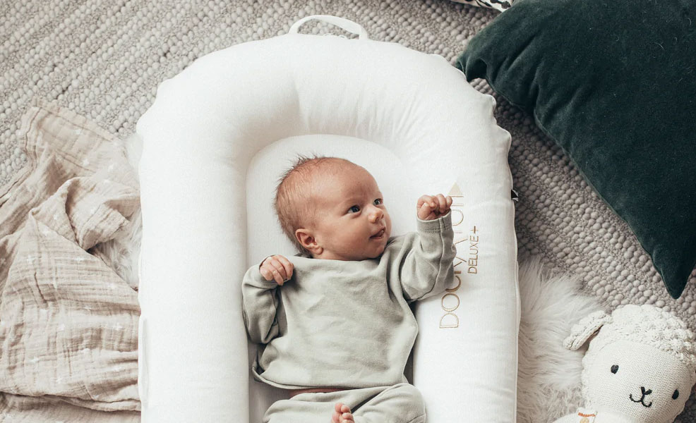 awake baby laying in a dockatot