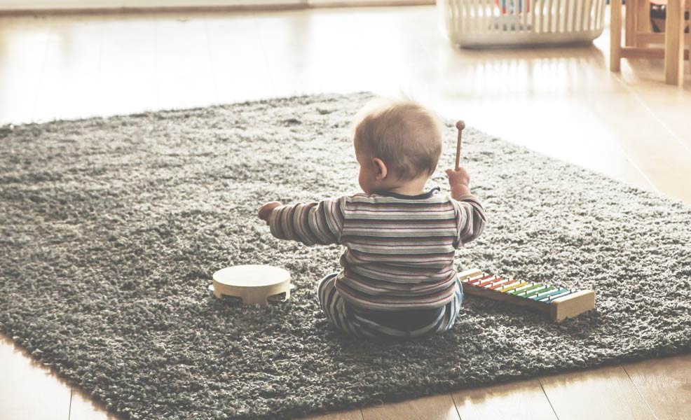 baby sitting and playing with learning toys