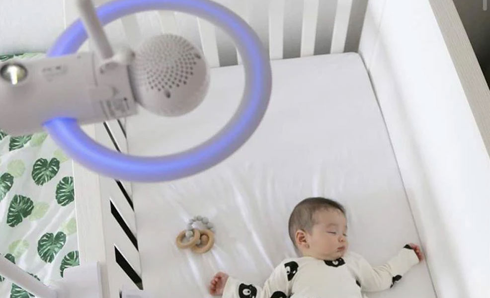 the motorola halo plus baby monitor above a crib with a sleeping baby