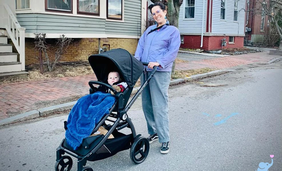 mom pushing baby in the peg perego ypsi stroller in urban setting