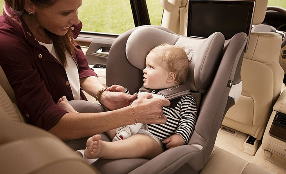 mom trying out a car seat with child