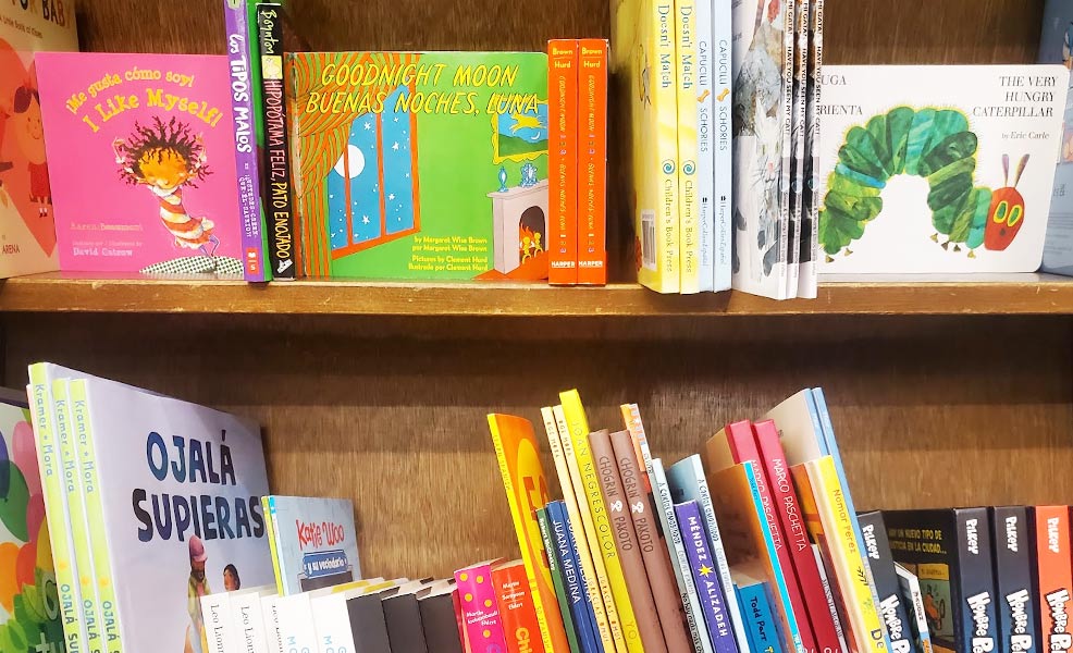 a bookshelf with spanish-english bilingual baby books