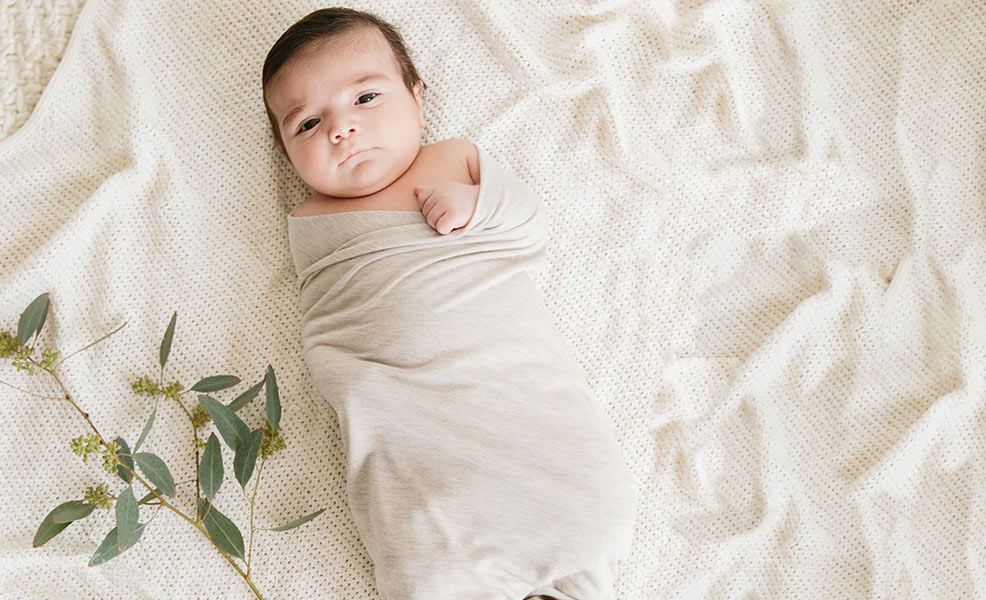 a baby relaxing in a solly swaddle