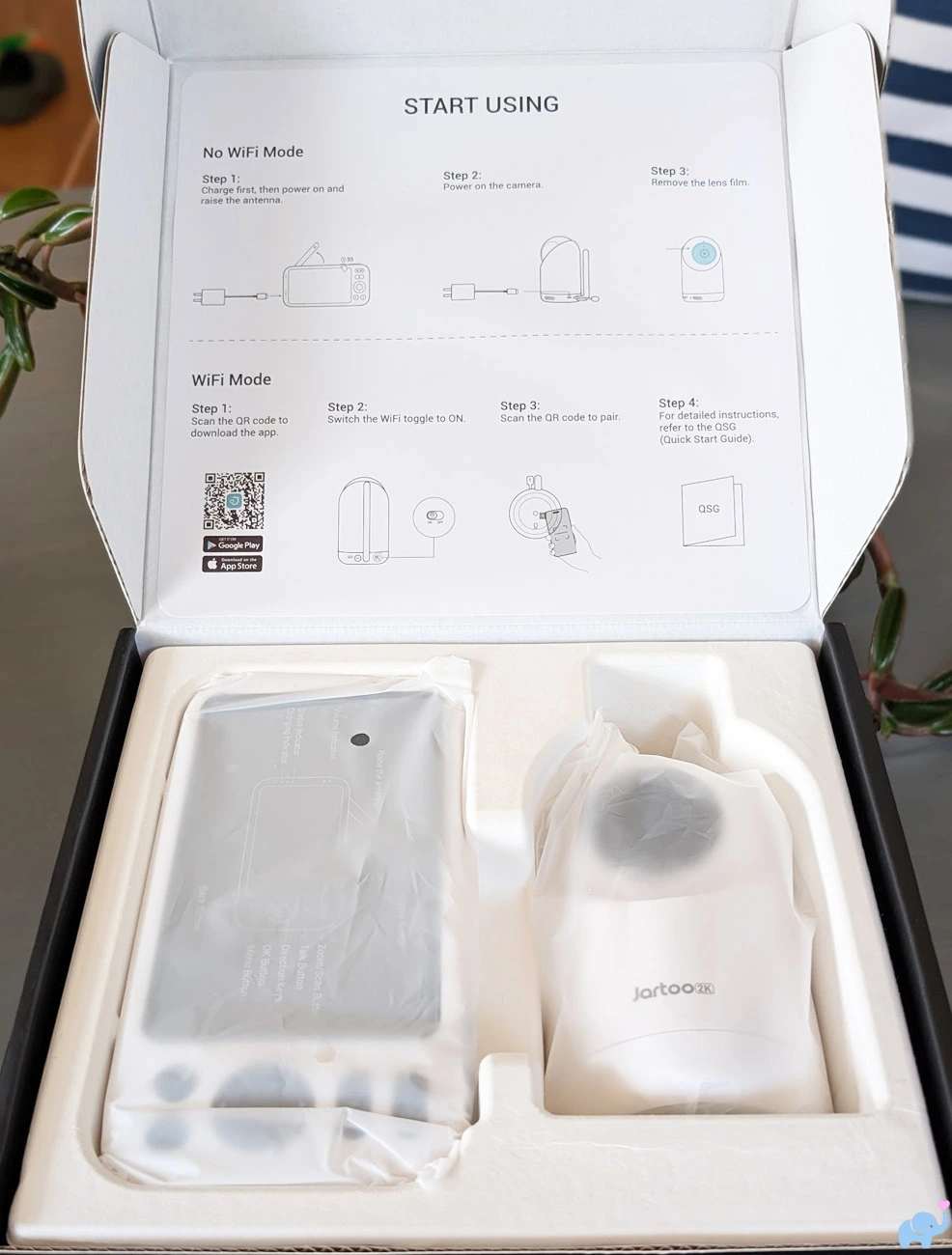 Jartoo JBM550 unboxing process showing the wrapped camera and parent unit inside the box