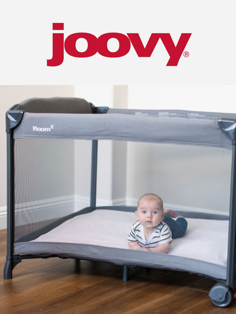 a baby doing tummy time in the joovy room2 travel crib