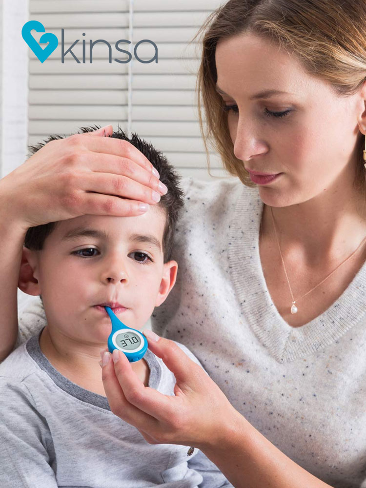 a mom taking a boys temperature with the kinsa smart thermometer