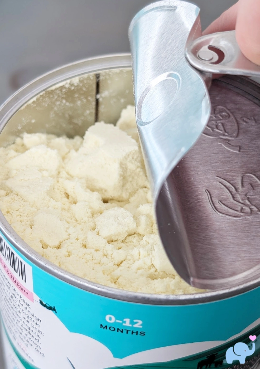 close-up of a Little Spoon formula tin being opened, revealing the off-white powder inside