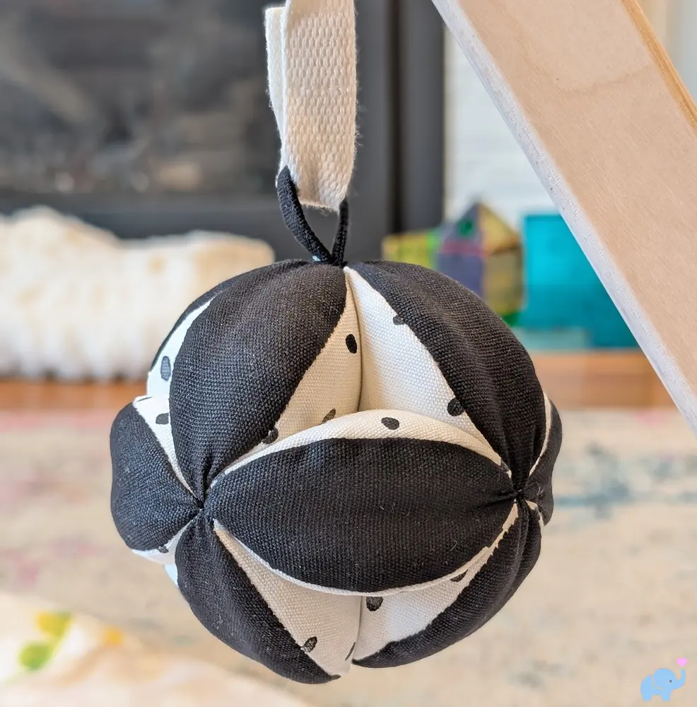 Black and white squishy hanging toy on the Lovevery Play Gym