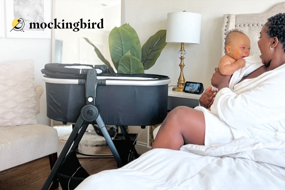 mockingbird bassinet stand positioned next to a bed