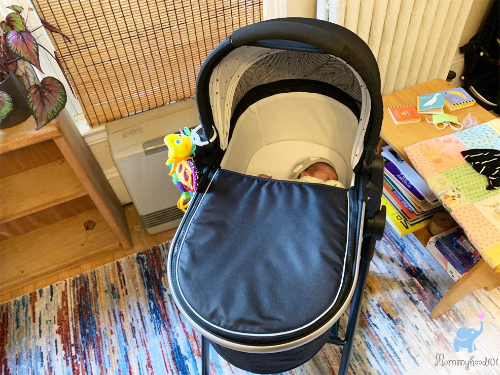 a sleeping baby in the mockingbird bassinet stand