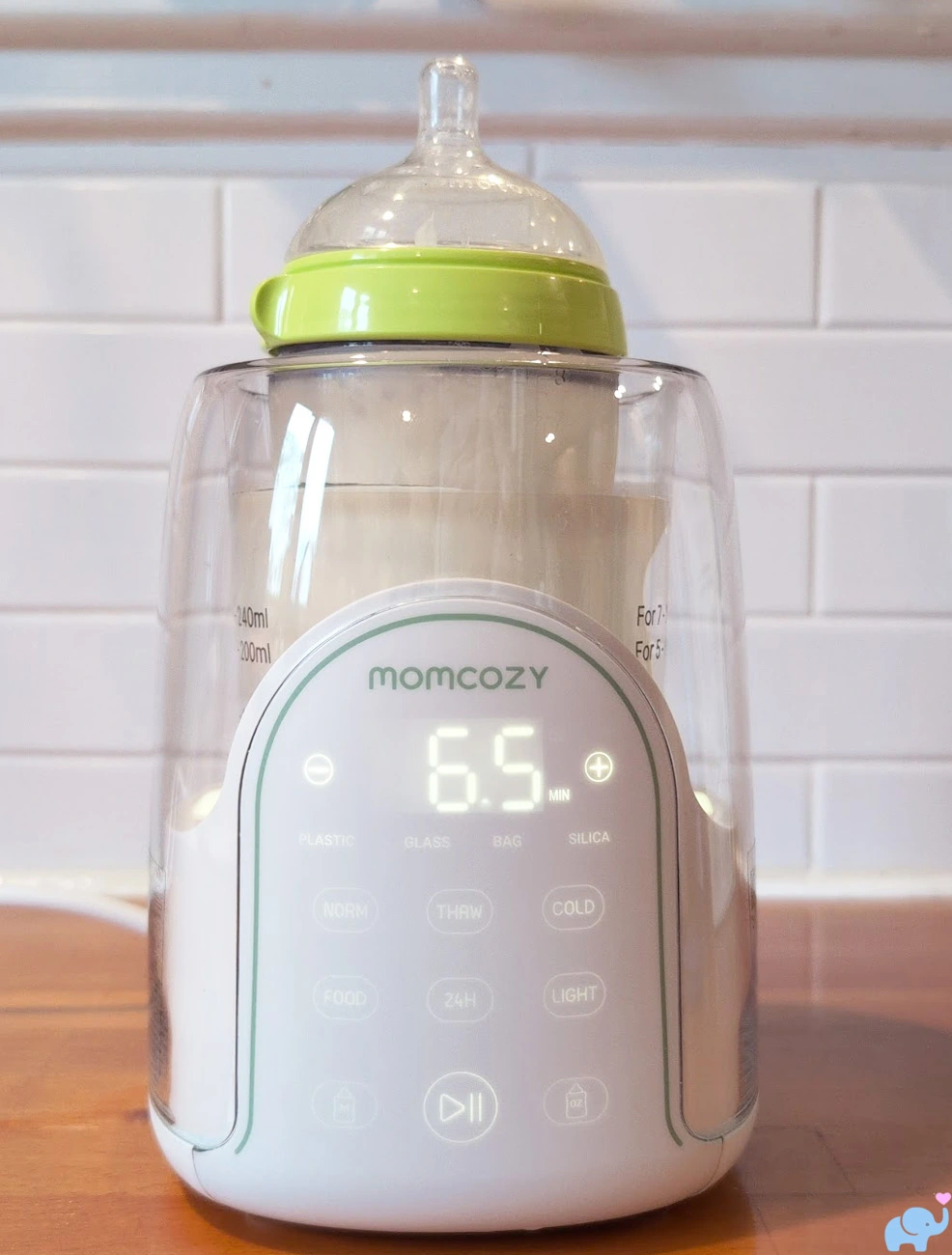 Comotomo wide silicone baby bottle fitting inside the Momcozy NightPro Baby Bottle Warmer