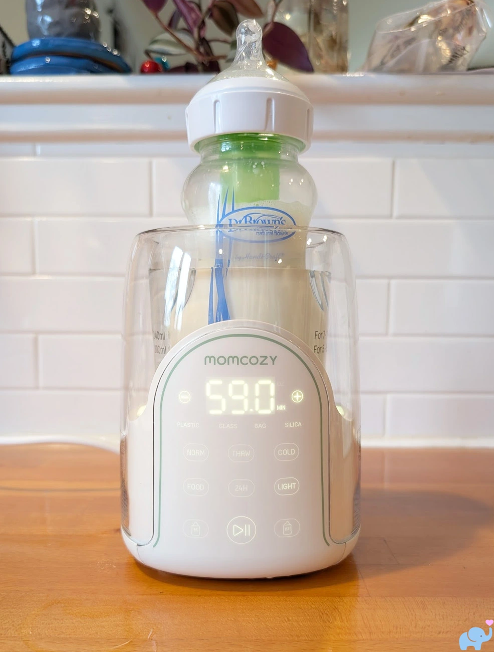 Dr Brown's glass baby bottle fitting inside the Momcozy NightPro Baby Bottle Warmer