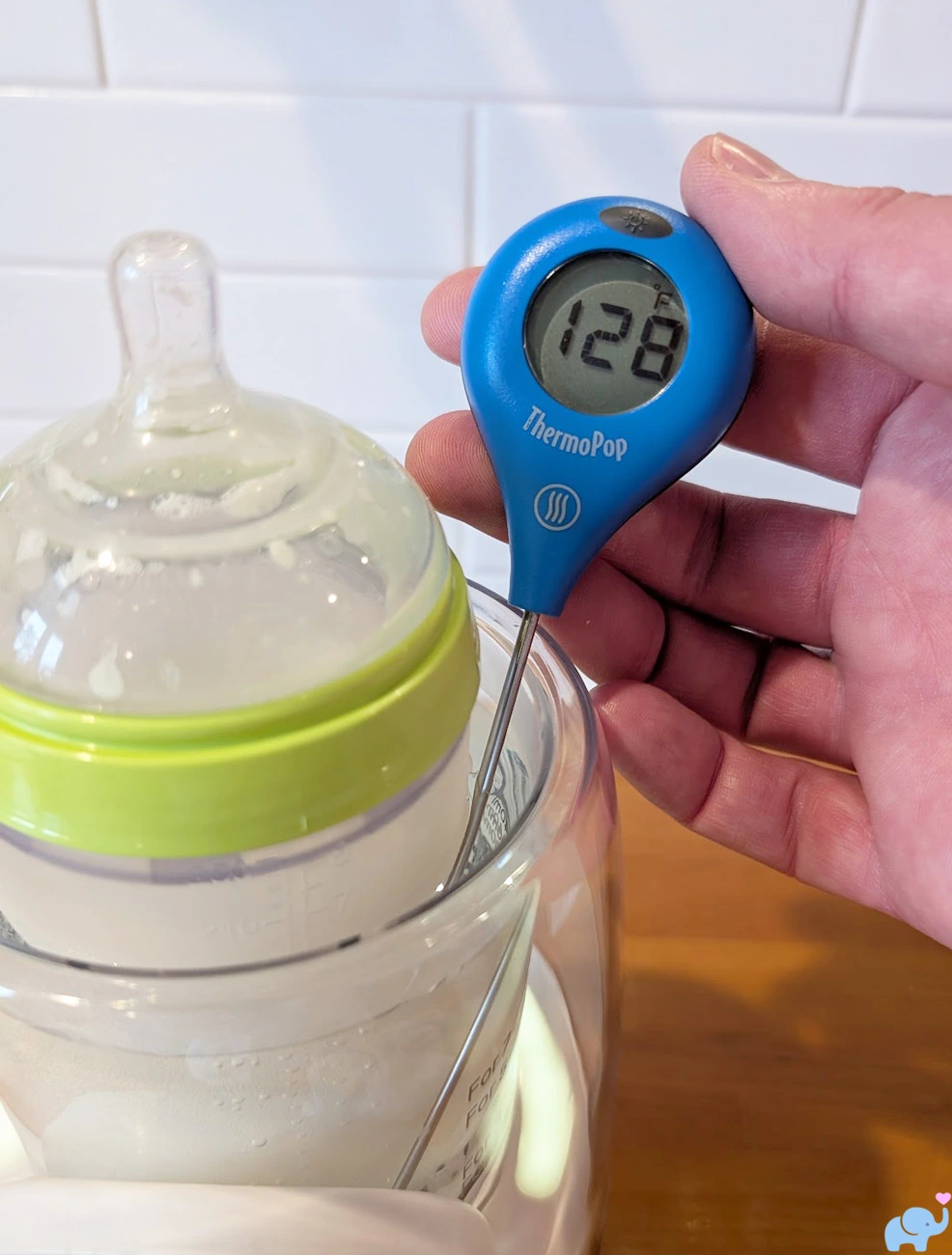 thermometer showing 128 degrees inside the Momcozy NightPro Bottle Warmer reservoir