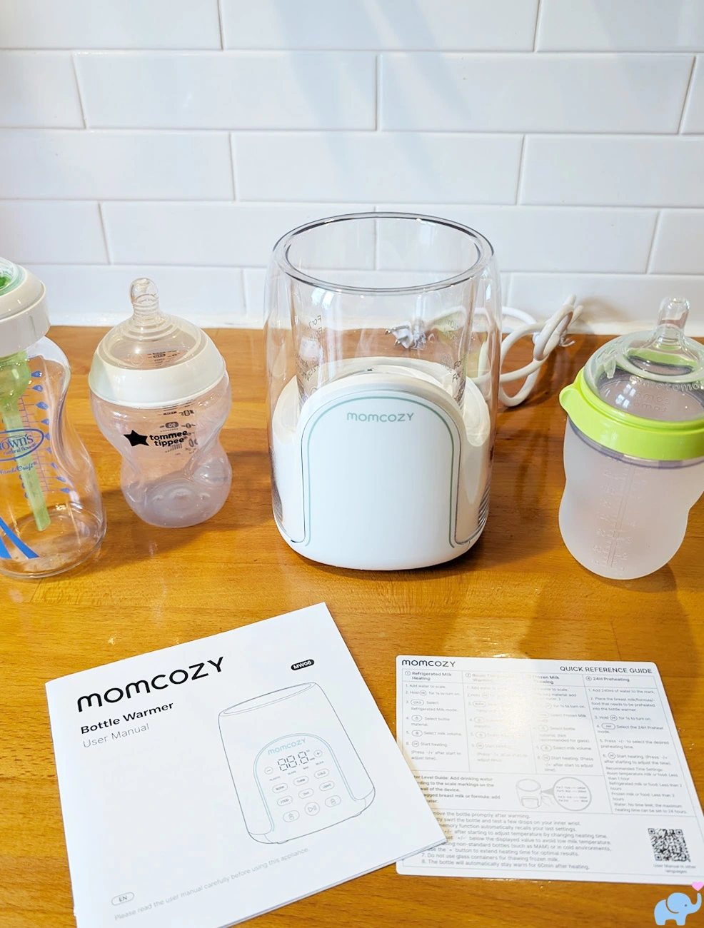 Momcozy NightPro Bottle Warmer unboxed with owner's manual quick start guide and three test bottles