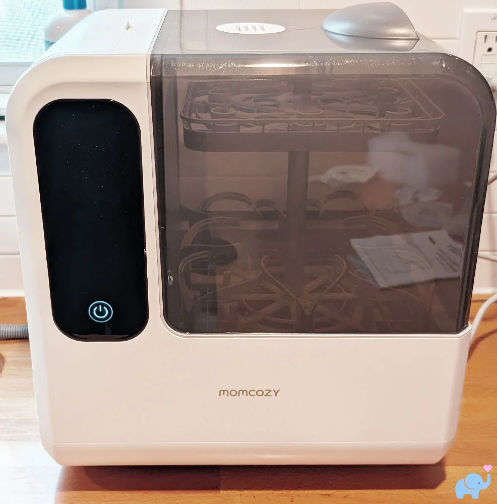 Momcozy DeepClean Baby Bottle Washer D8 fully set up on kitchen counter with hose and power connected