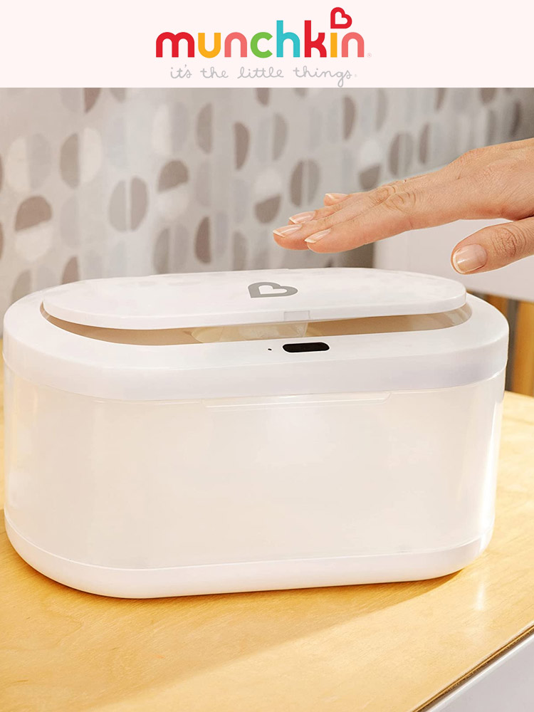 a hand hovering over the munchkin touch free wipe warmer to open the lid