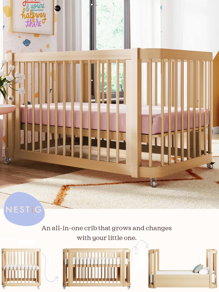 the wooden nestig wave crib with a pink mattress on top of a rug in a nursery with art on the wall with demonstration of how the crib converts from mini crib to toddler bed