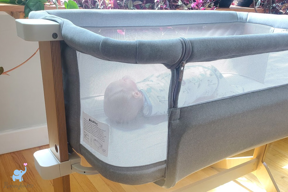 a side view of the newton bassinet with a baby inside