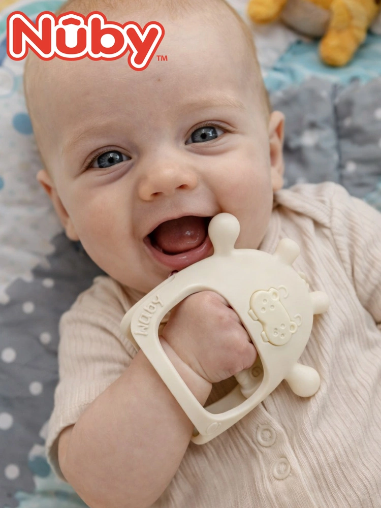 a smiling baby wearing the Nuby teething mitten