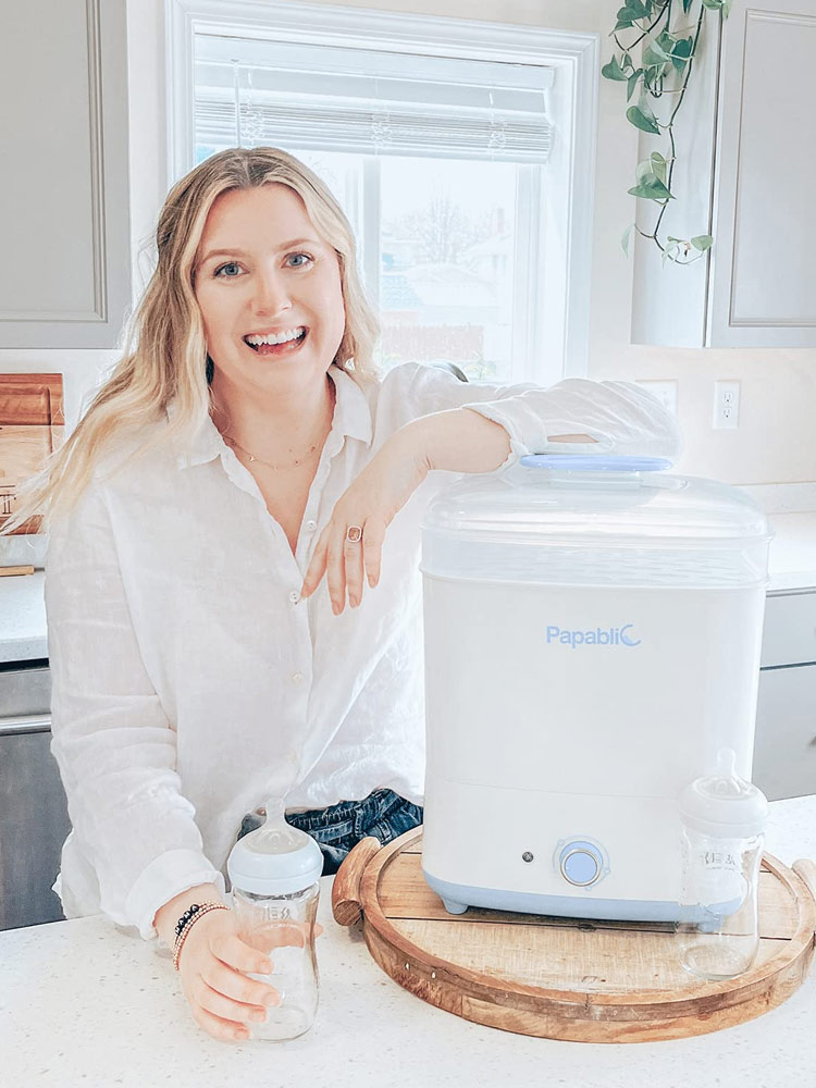 a mom in the kitchen using a papablic sterilizer and dryer