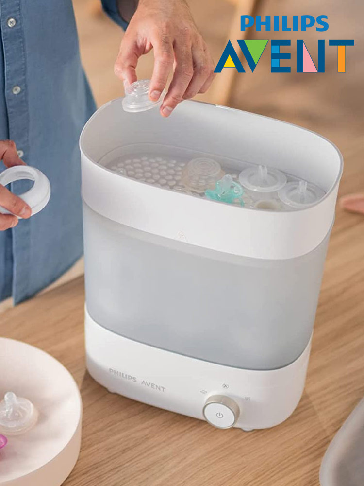 a parent placing baby bottle nipples into the philips avent 3in1 sterilizer
