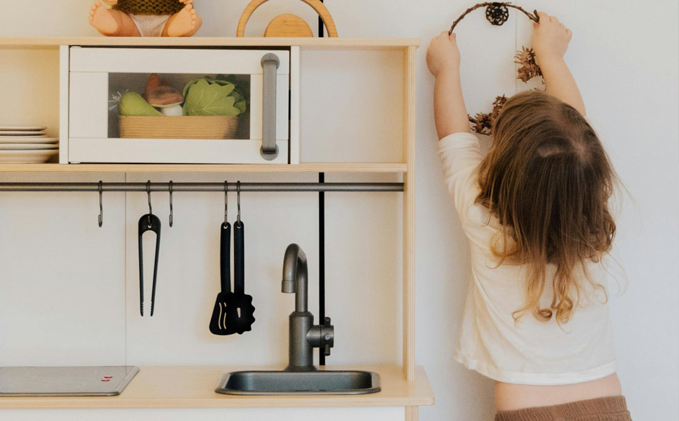 boy playing next to a play kitchen