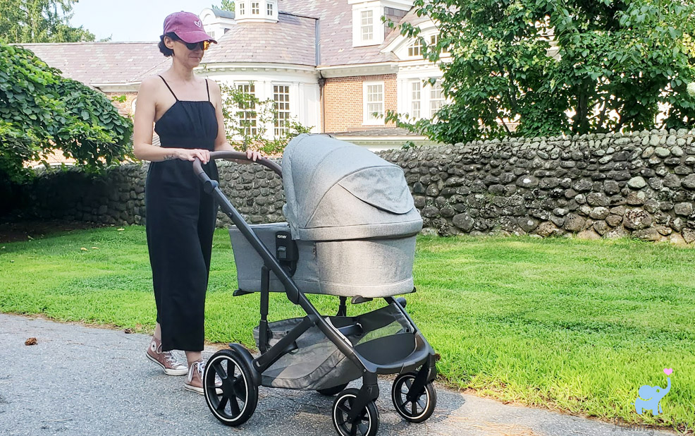 romer sera bassinet and tura stroller on the street with baby