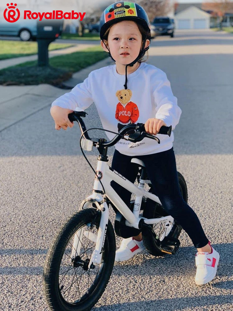 a kid riding a royalbaby bike in his suburban neighborhood