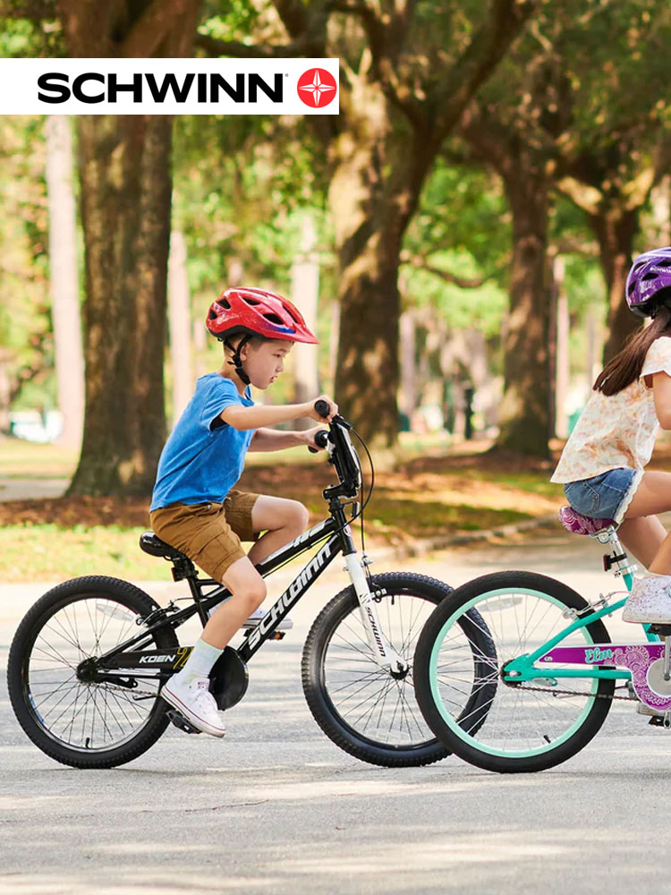 two kids riding schwinn bikes in the park