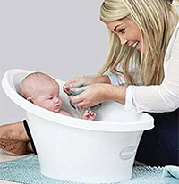 a parent bathing a baby in the shnuggle beaba bathtub