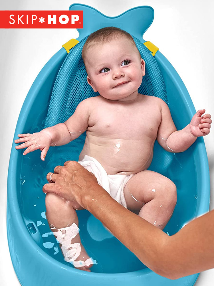 a parent bathing a baby in the skip hop moby bathtub