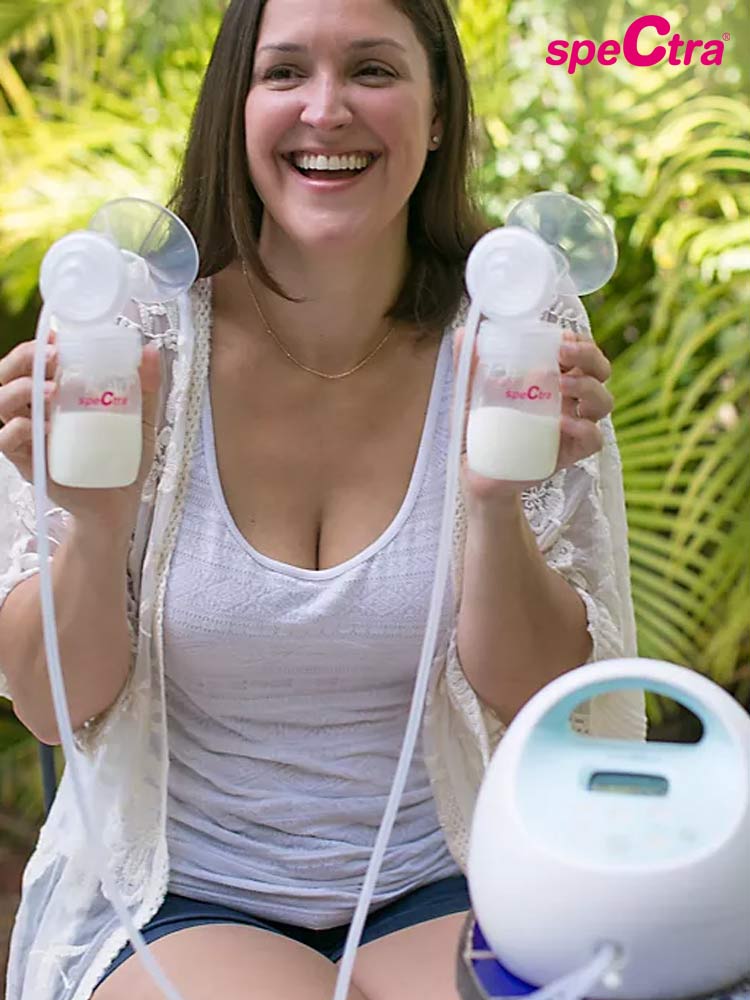 smiling mom holding the spectra s1 breast pump