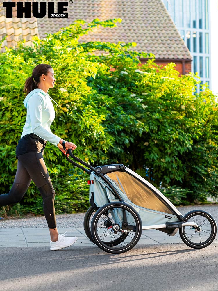 a mom jogging while pushing the thule chariot cross multisport stroller