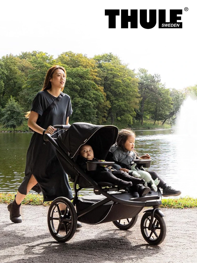 a mom pushing two children through in the thule urban glide 3 double stroller