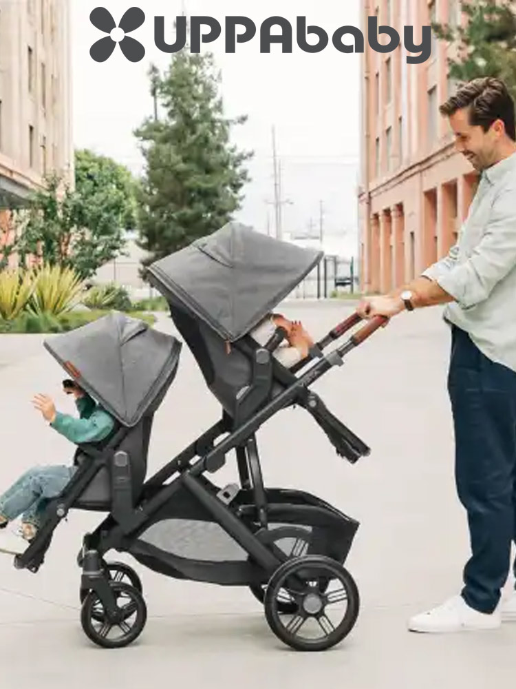 a dad pushing two kids in double uppababy vista v3 stroller