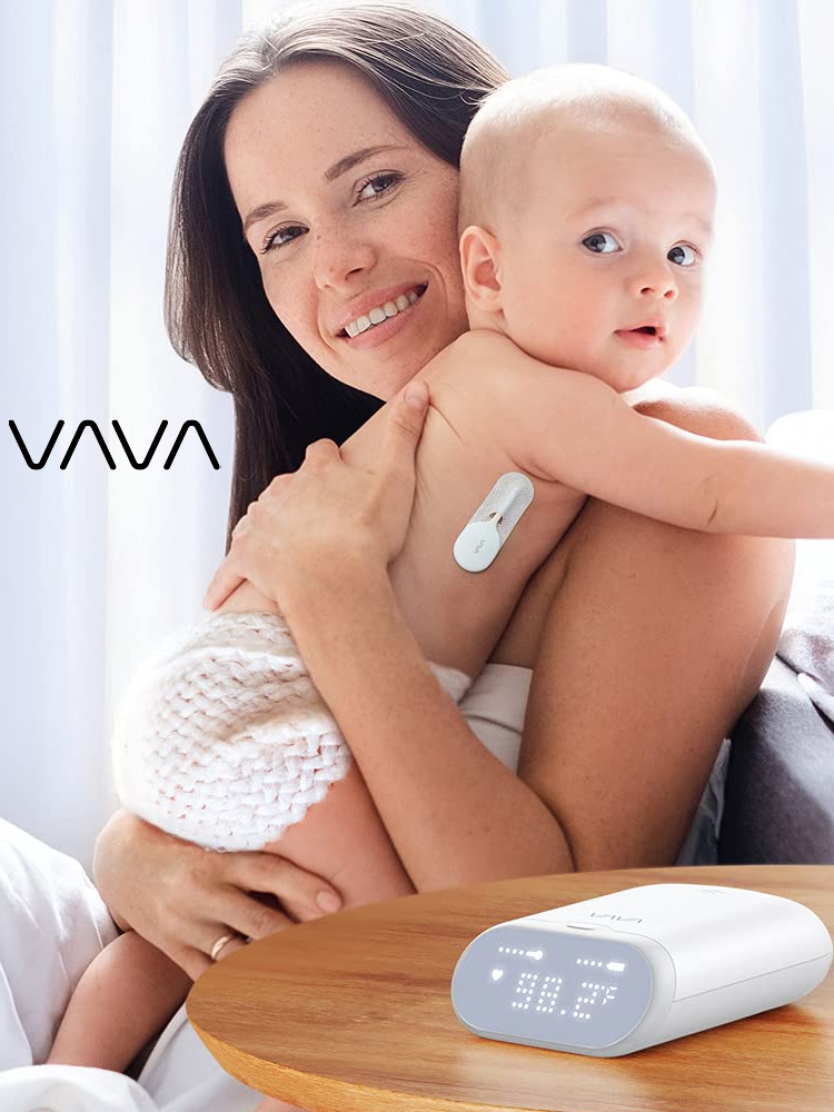 a mom holding a baby who is wearing the vava smart baby thermometer