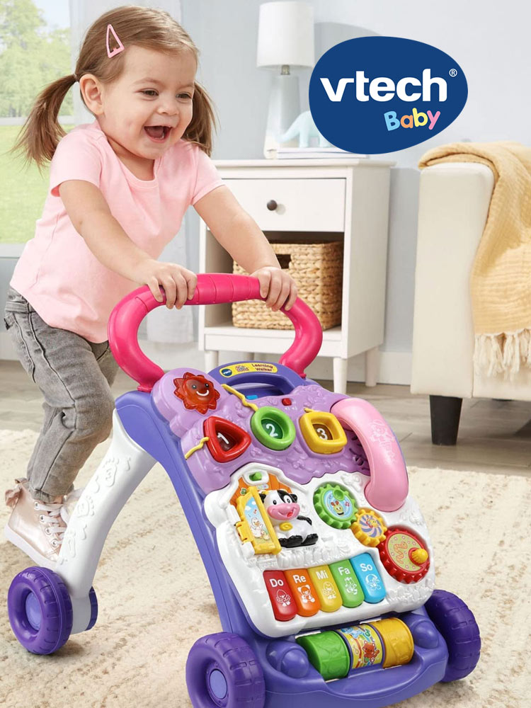 a young smiling girl pushing the vtech sit-to-stand walker